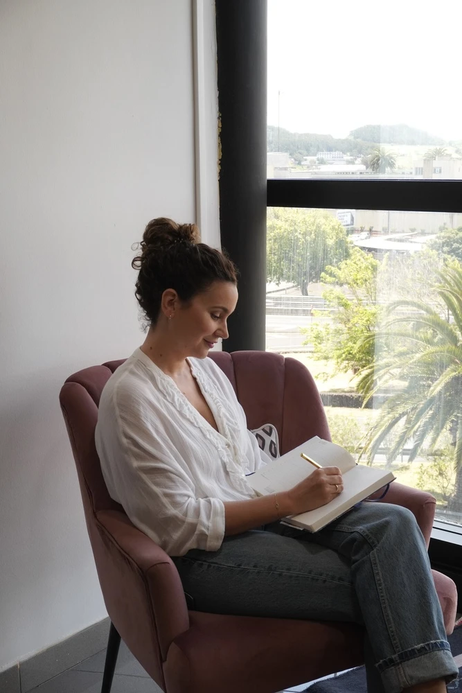 Claudia González tomando notas junto a la ventana de su consulta de psicología en Tenerife